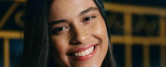 young teen smiling with dark background